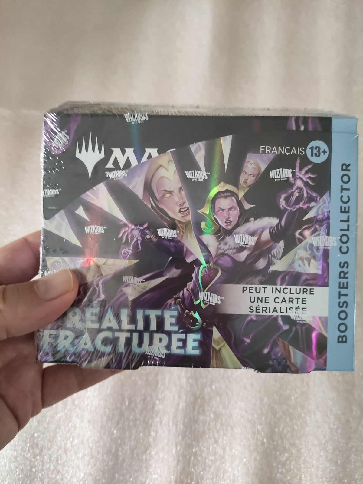 Boîte de 12 boosters Magic: The Gathering – Réalité fracturée, collection de cartes à jouer Wizards of the Coast, en main.