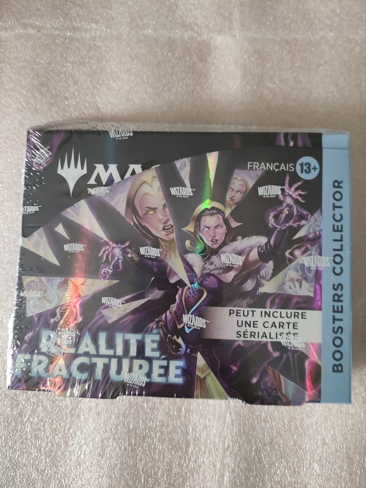 Jeu de cartes Magic: The Gathering Réalité fracturée, display de 12 boosters Collector, en main, par Wizards of the Coast.