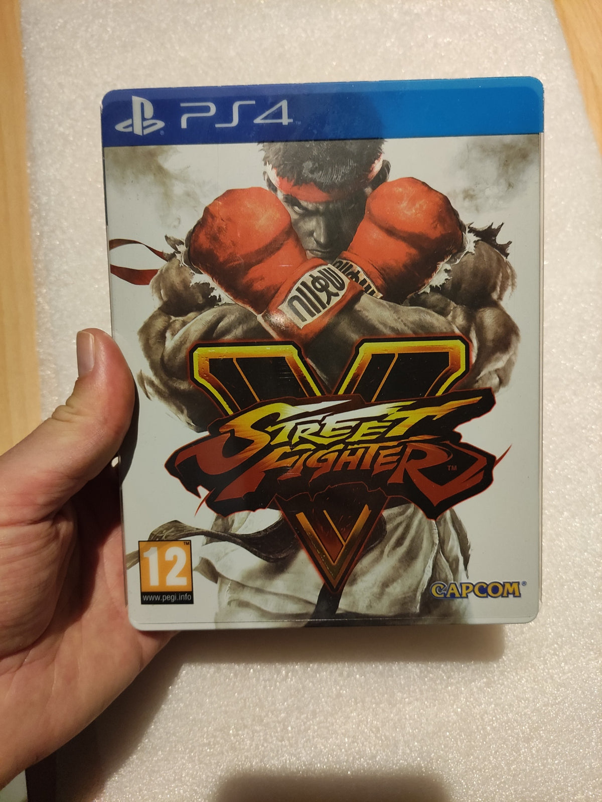 Jeu PS4 Street Fighter V – Steelbook Edition de Capcom avec jaquette colorée et artwork de personnages de combat.